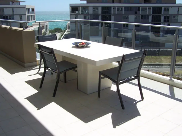 Balcony dining table: A pale rectangular dining table in an outdoor setting.