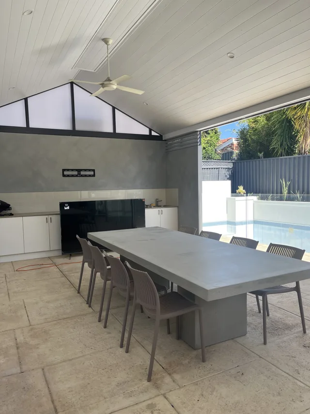 Covered outdoor dining: A rectangular dining table in a covered entertaining space.