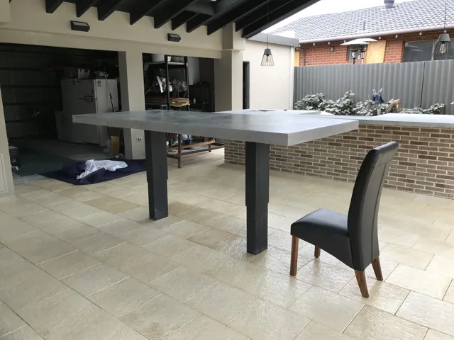 Outdoor bar table: A raised rectangular top on dark legs, shown on site.