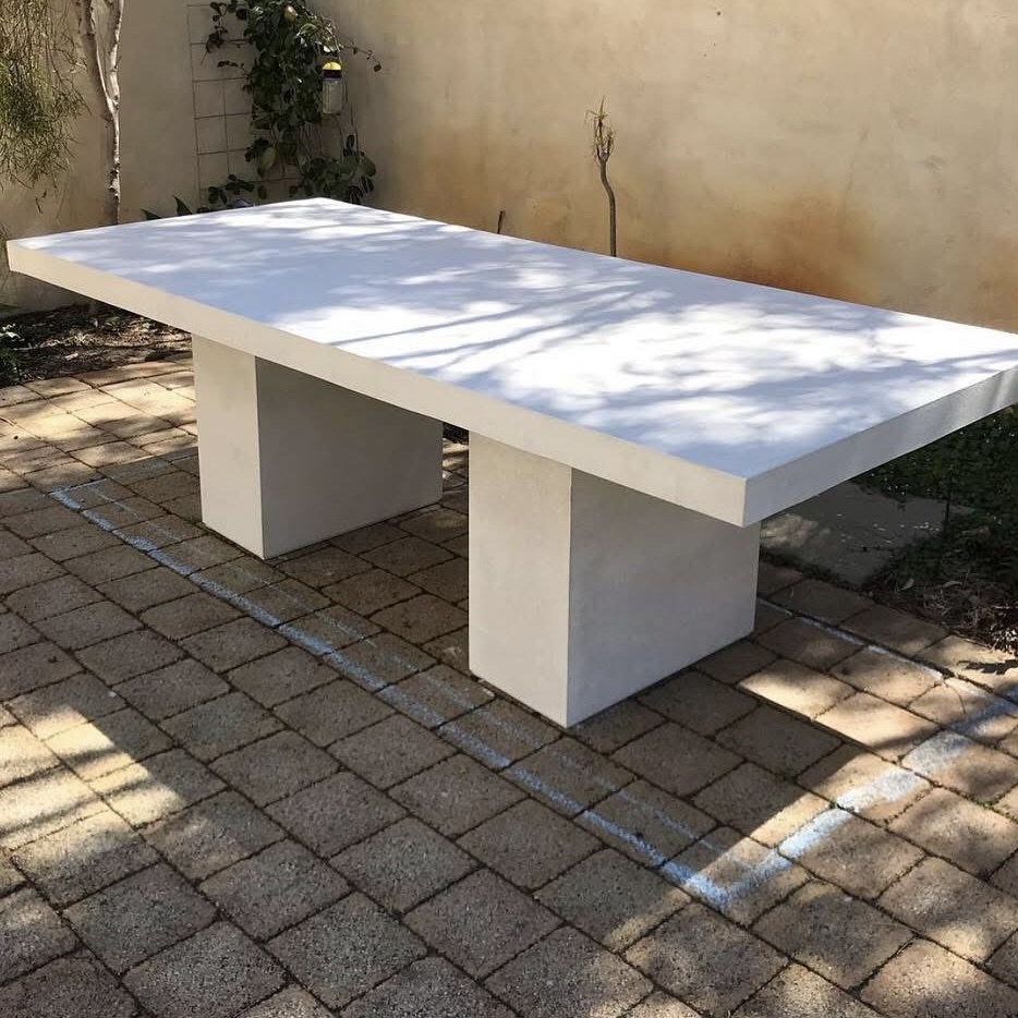 Rectangular dining table: A pale rectangular top with two slab bases.