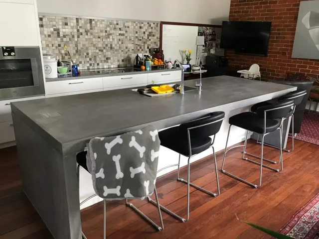 Waterfall kitchen island: A grey island surface with a waterfall end and integrated sink.